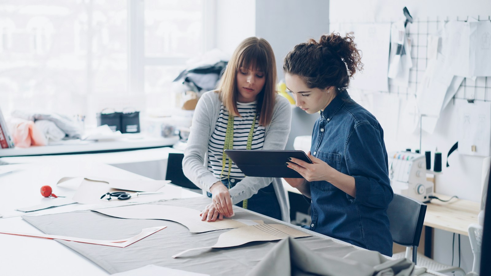 Dos profesionales de un estudio creativo revisando un proyecto con una tableta